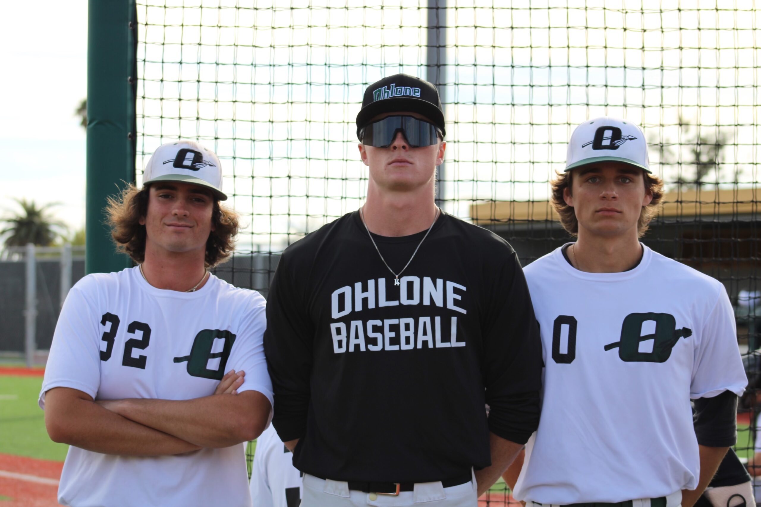 A man wearing black and two men wearing white shirts standing together